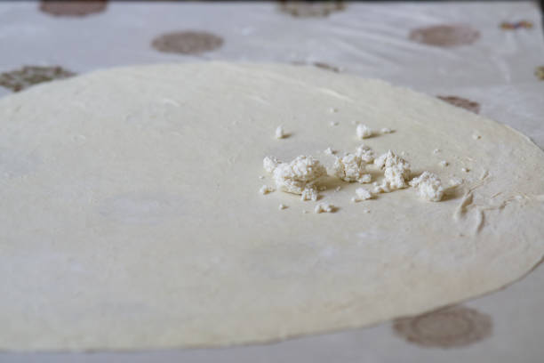 istock Rolled out dough with crambled cheese close up 2166338866