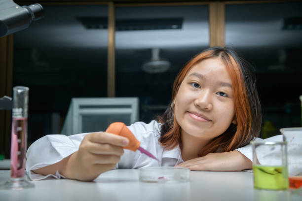 istock girl scientist using Dropper with Rubber Test. education and science 2166339143