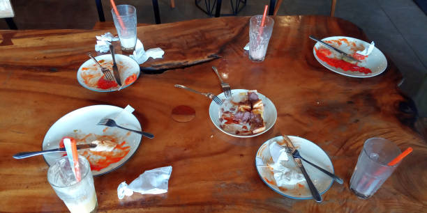 The leftover food and dirty empty dishes on the restaurant table. symbolize the end of lunch or dinner. Scraps left over after the party.