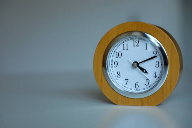 istock Desktop classic yellow clock close-up on a white background. Never leave that till tomorrow which you can do today. Time is money. 2166350948