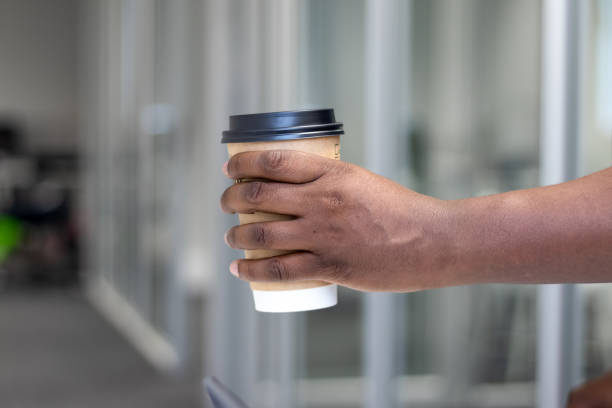 istock An African man holds a disposable brown cup for coffee or tea. 2166352057