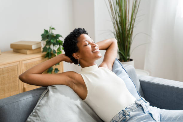 istock Young woman relaxing on sofa at home taking deep breath 2166353297