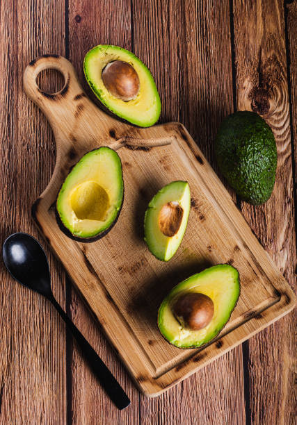 istock zenithal view of open avocado with visible stone, on a wooden board, on a table, copy space 2166354328