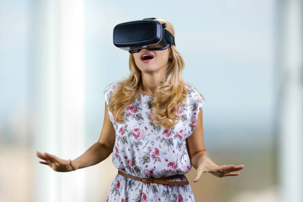 Surprised young woman experiences virtual reality in headset.