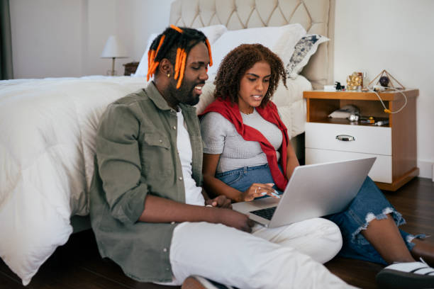 istock Young couple using laptop together in the bedroom 2166356849