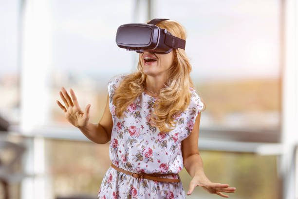 istock Amazed young woman experiences virtual reality in headset. 2166358525
