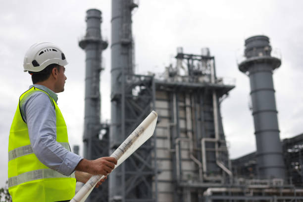 istock Electrical engineers, holding blueprints, look confident at the thermal power plant while working on project planning to produce high-voltage electrical energy, emphasizing the energy concept. 2166360193