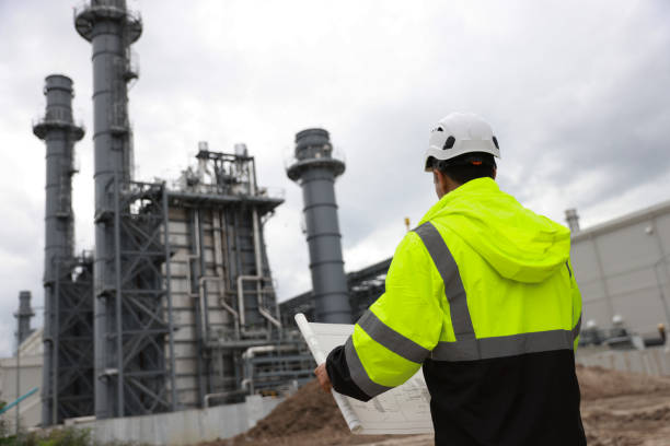 istock Electrical engineers, holding blueprints, look confident at the thermal power plant while working on project planning to produce high-voltage electrical energy, emphasizing the energy concept. 2166360202