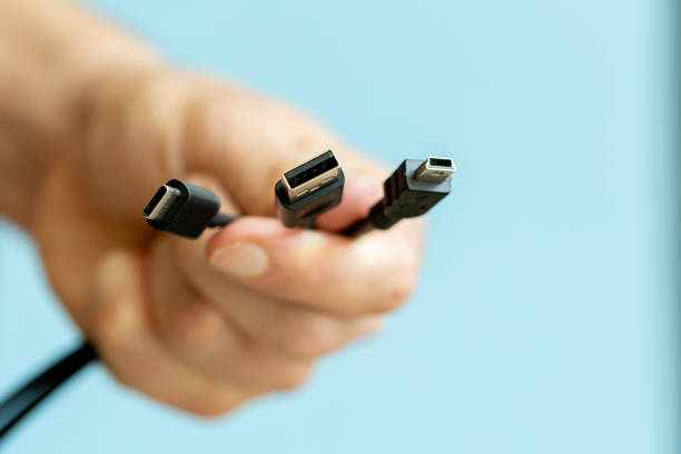 man holding several cables in hand, different types of USB cables, technology and connection concept