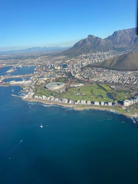 Stunning view of Cape town from a helicopter over the ocean, view of DHL stadium, waterfront and beautiful city buildings from above on a sunny day