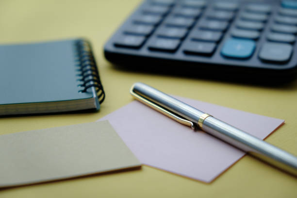 Office notebook with a pencil and a calculator on a yellow background