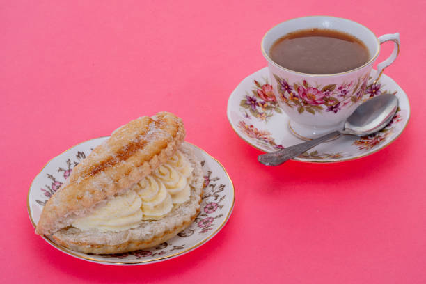 A cream cake with a cup of tea - pink background