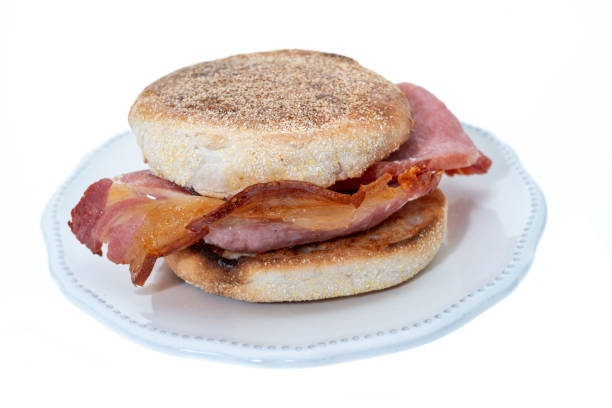 Toasted English muffin bacon sandwich - white background