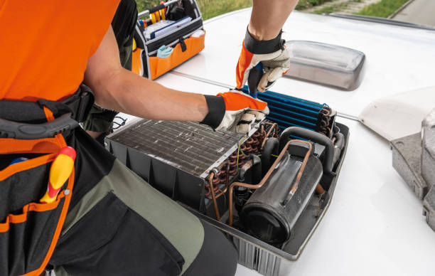 istock Technician Servicing RV Camper Rooftop HVAC Unit During Daytime in an Urban Setting 2166368301