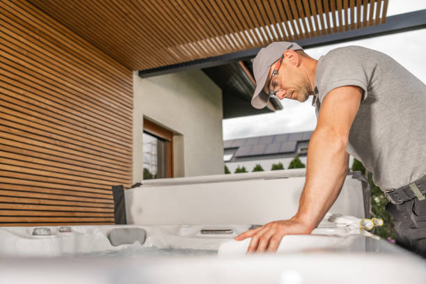 Technician Servicing a Hot Tub in a Modern Backyard During the Afternoon