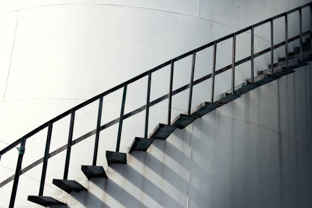istock Large industrial cylinder storage tanks and spiral staircase 2166369622