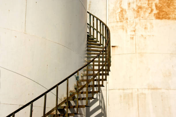 istock Large industrial cylinder storage tanks and spiral staircase 2166369634