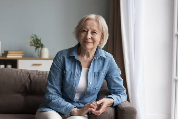 istock Calm retired elderly woman resting seated on comfortable couch 2166370277