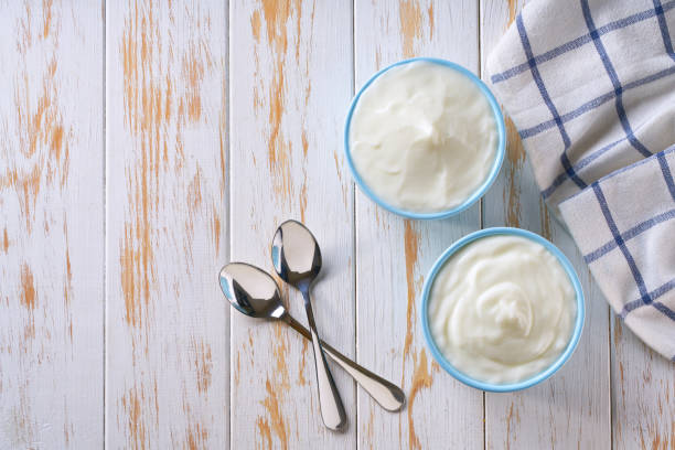 istock homemade organic yogurt in a blue ceramic bowls  on a white table, top view. 2166374391