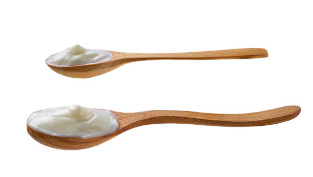 istock wooden spoon with yogurt isolated on a white background. 2166374412