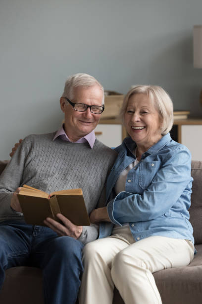 istock Retired husband and wife spend time reading book at home 2166375964