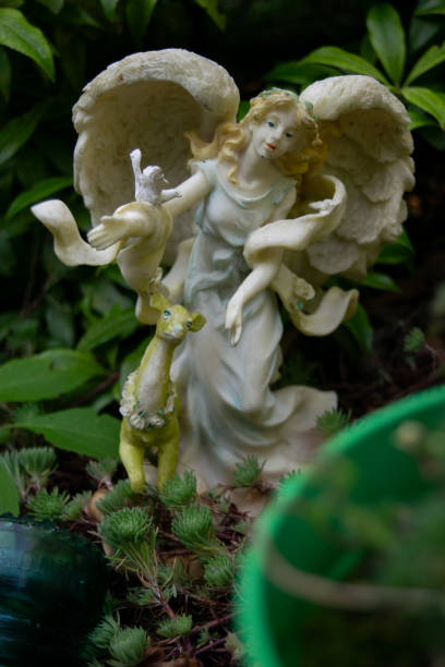 A vibrant garden scene with colorful flowers and unique sculptures in a lush setting, under a clear sky.
