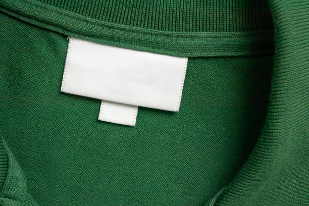 istock Blank white laundry care clothes label on green shirt fabric texture background 2166381523