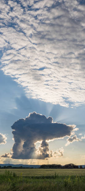 istock An unusually shaped cloud hangs low against a green field 2166381944