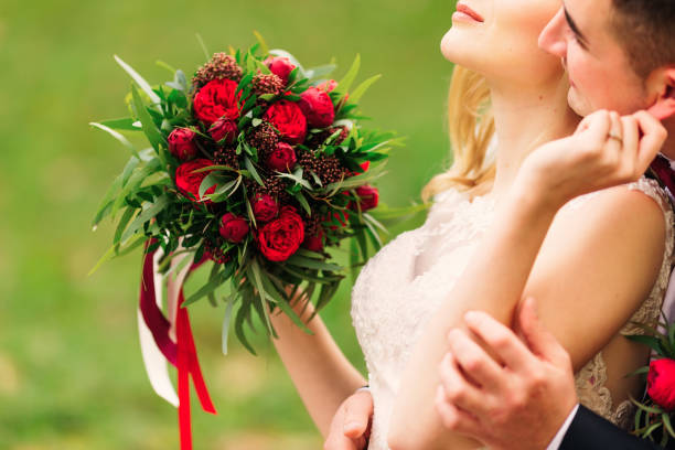 istock bride holding wedding bouquet. beautiful red peonies. hugging. 2166382597