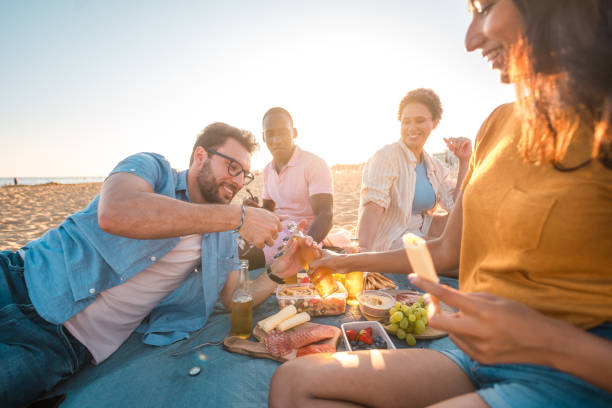 istock Cheerful Multi-Ethnic People Doing A Picnic At The Beach 2166383355