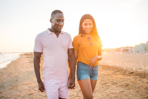 istock Young Multiracial Couple on a Romantic Stroll At The Seaside 2166383483
