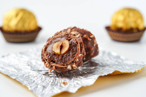 Sweet chocolate balls is made. Chocolate candy in gold wrapper on white background