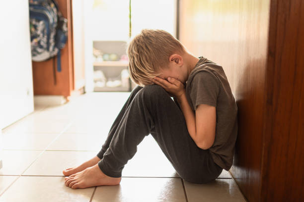 istock Sad little boy alone sitting on the floor. 2166389344
