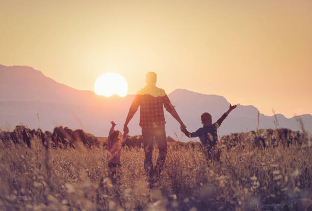 istock Father walking with his children in sunset. 2166389437