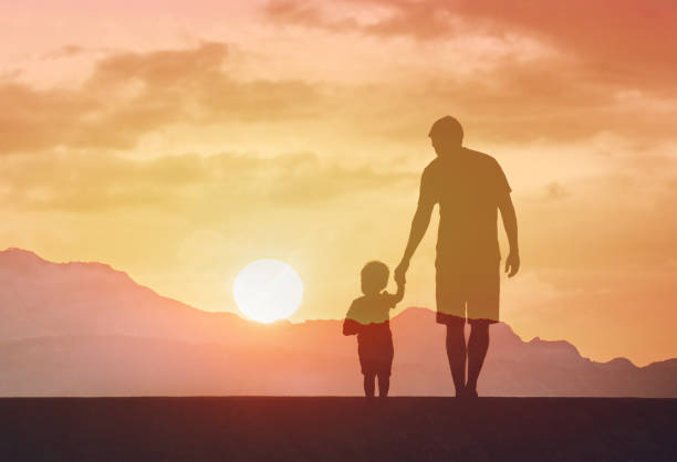 istock Father and son walking through a countryside at sunset. 2166389528