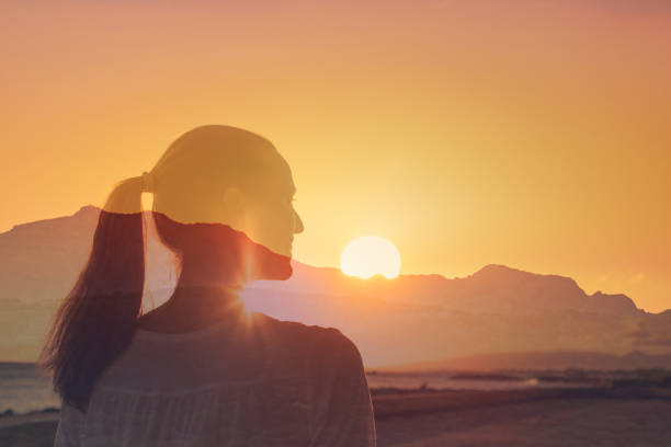 istock Woman watching beautiful sunset from the beach. 2166389533
