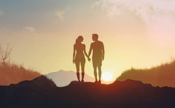 istock Couple holding hands and walking at sunset. 2166389759