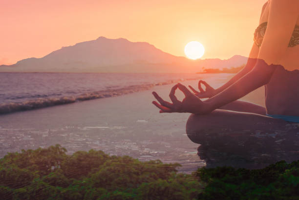 istock Woman meditating on the beach at sunset. 2166389992