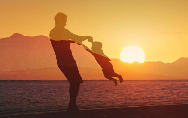 Father and son playing together on the beach.