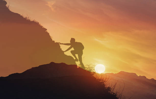 istock Young man climbing up a mountain. 2166390705
