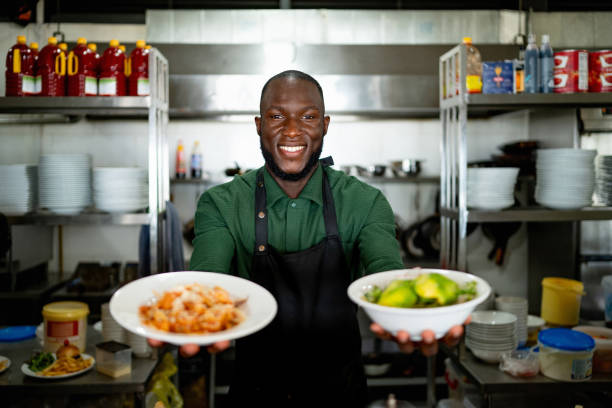 istock Happy chef holding a plate with ingredients at a restaurant 2166394295
