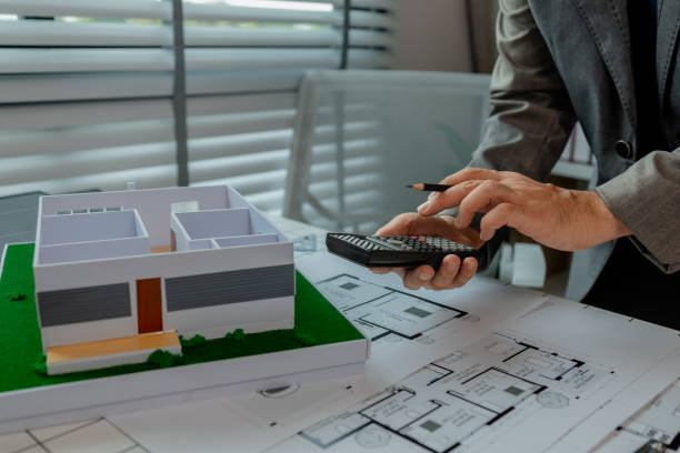 istock An engineer is calculating whether the structural proportions of a house model are correct with a calculator, an architect is using calculator to check numbers from a blueprint 2166395304
