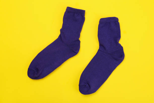 istock Pair of violet socks on yellow background 2166395865