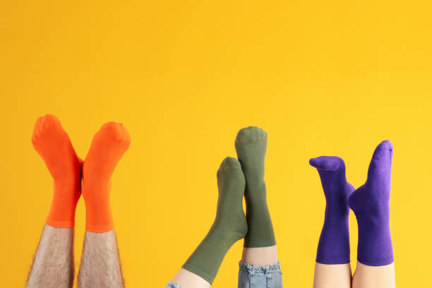 istock Legs in different socks on yellow background 2166397832