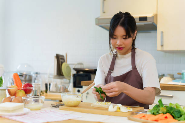 istock Asian women is putting boiled egg salad and vegetables on bread to making sandwich while preparing ingredients for cooking breakfast meal and making healthy food lifestyle in the kitchen at home 2166399865