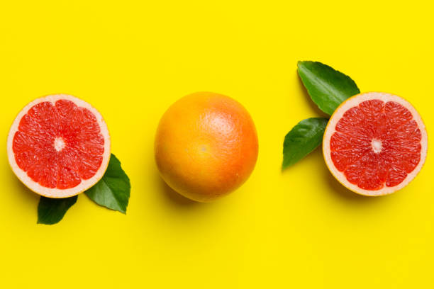 istock fresh Fruit grapefruit with Juicy grapefruit slices on colored background. Top view. Copy Space. creative summer concept. Half of citrus in minimal flat lay with copy space 2166405871