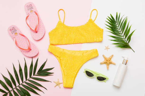 Traveler accessories, women summer bikini set swimsuit on table background with empty space for text. Travel vacation concept. Flat lay, top view Female sexy swimwear.