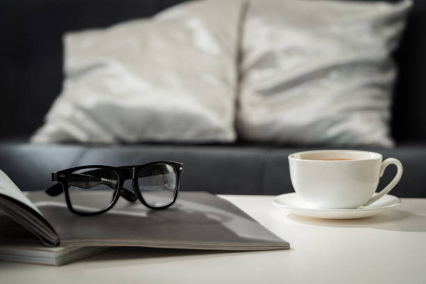 istock A Cup of Coffee, Glasses, and a Stack of Magazines on a White Tabletop 2166406601