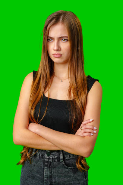 istock Young Woman With Arms Crossed Looking Off Camera With Serious Expression 2166407519