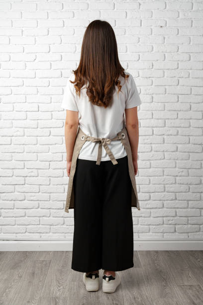 istock Back view Woman Wearing Apron in Front of a White Brick Wall 2166408363
